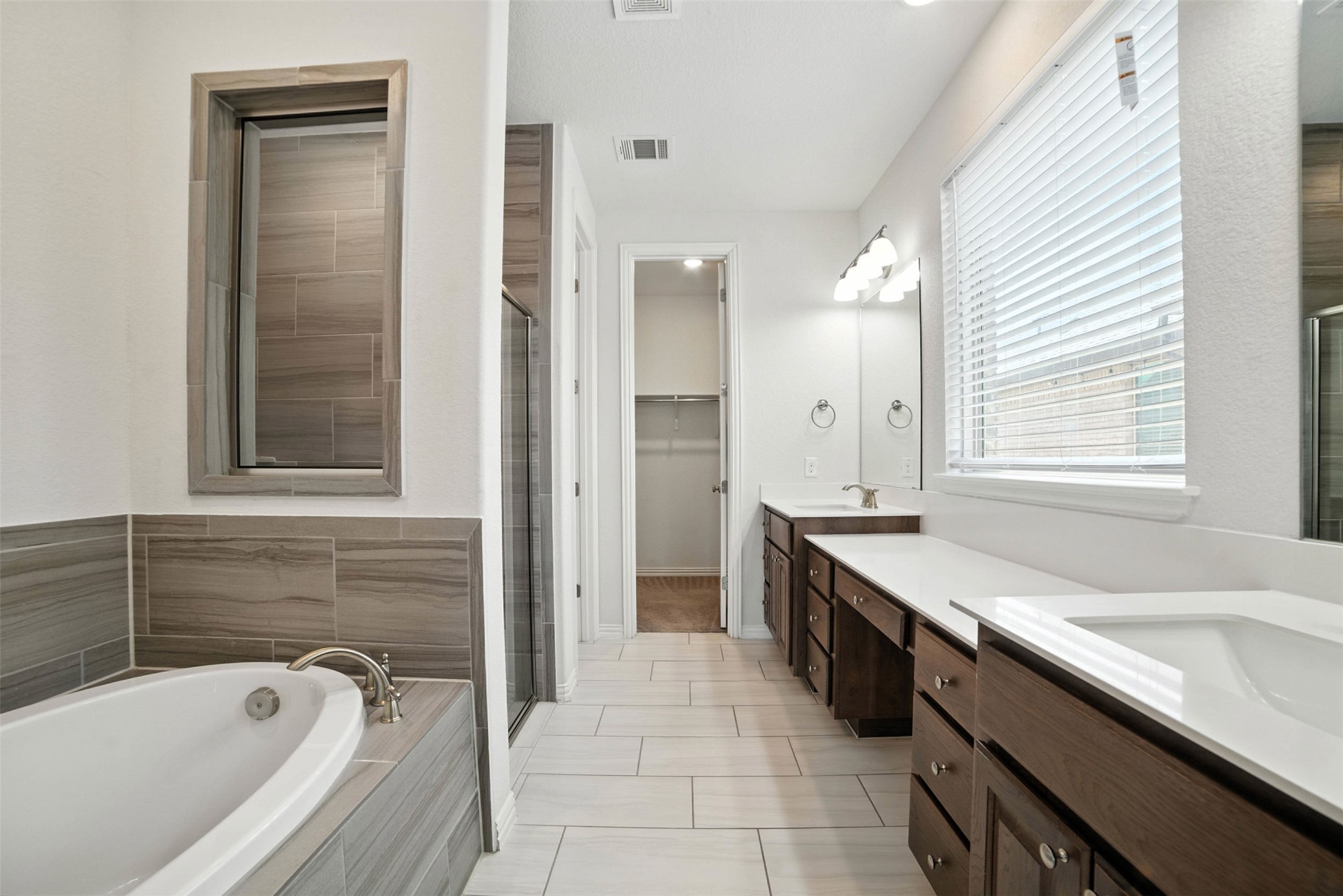 3054 Columbus Loop Round Rock, TX 78665 - Photo 18 of 40 Full bathroom featuring vanity, a bath, a shower stall, tile patterned floors, and a spacious closet