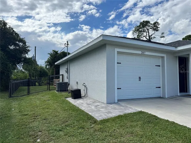 a backyard of a house with table and chairs