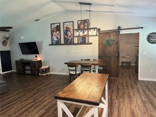 a living room with furniture a flat screen tv and a wooden floor