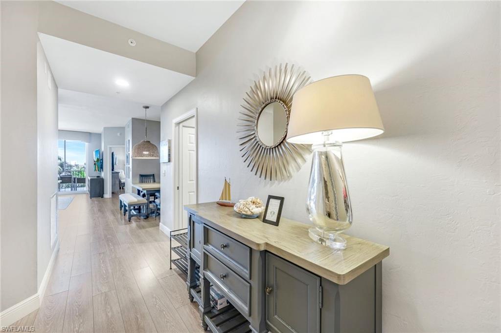 470 Launch Circle, Unit 403 Naples, FL 34108 - Photo 14 of 25 a kitchen with a sink dishwasher a dining table and chairs with wooden floor