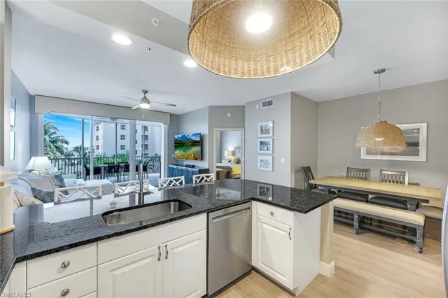 a kitchen with granite countertop a sink a stove and cabinets