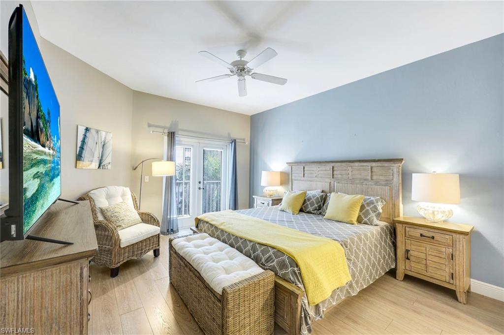 470 Launch Circle, Unit 403 Naples, FL 34108 - Photo 8 of 25 a bedroom with a bed and a chandelier