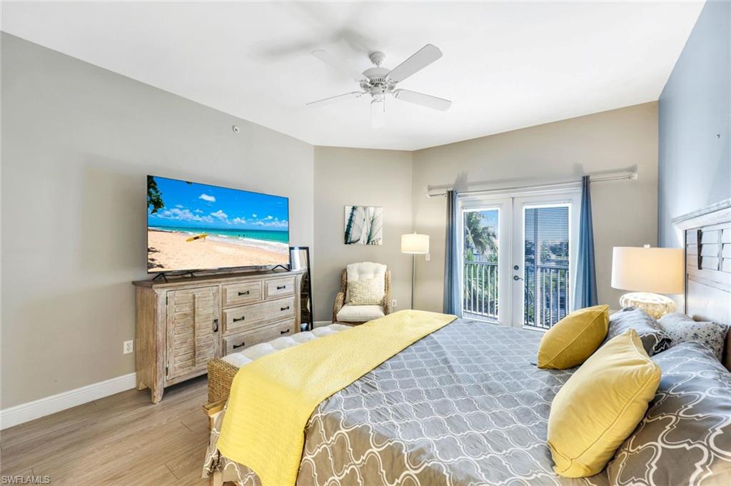 470 Launch Circle, Unit 403 Naples, FL 34108 - Photo 9 of 25 a bedroom with a bed and wooden floor