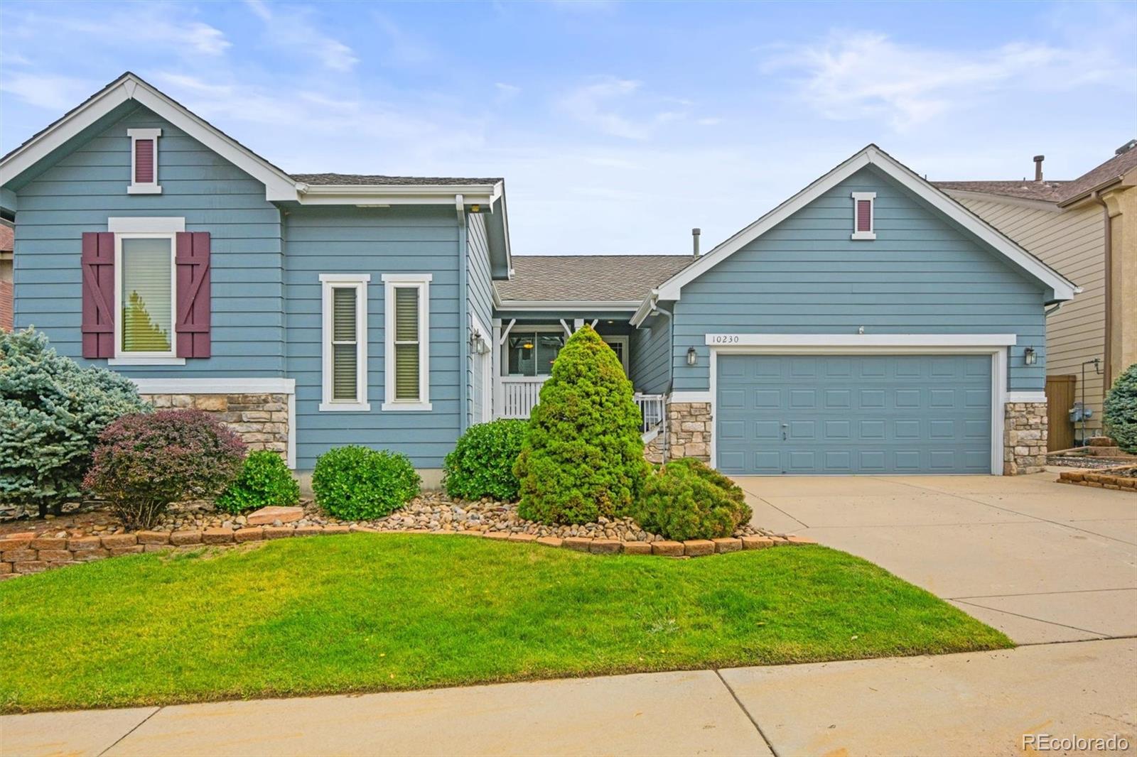 a front view of a house with a garden and yard
