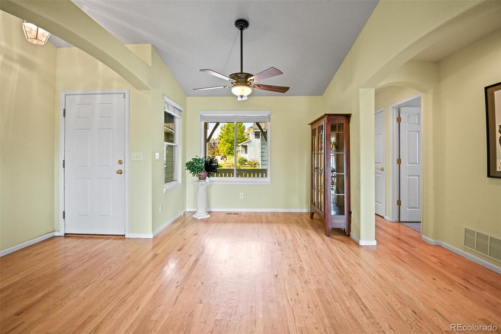 10230 Rustic Redwood Way Highlands Ranch, CO 80126 - Photo 11 of 50 a view of a livingroom with wooden floor a ceiling fan and windows