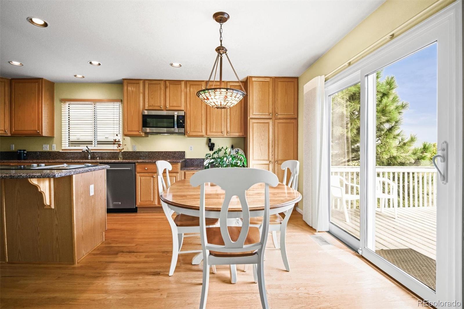 10230 Rustic Redwood Way Highlands Ranch, CO 80126 - Photo 12 of 50 a dining room with furniture a chandelier and wooden floor