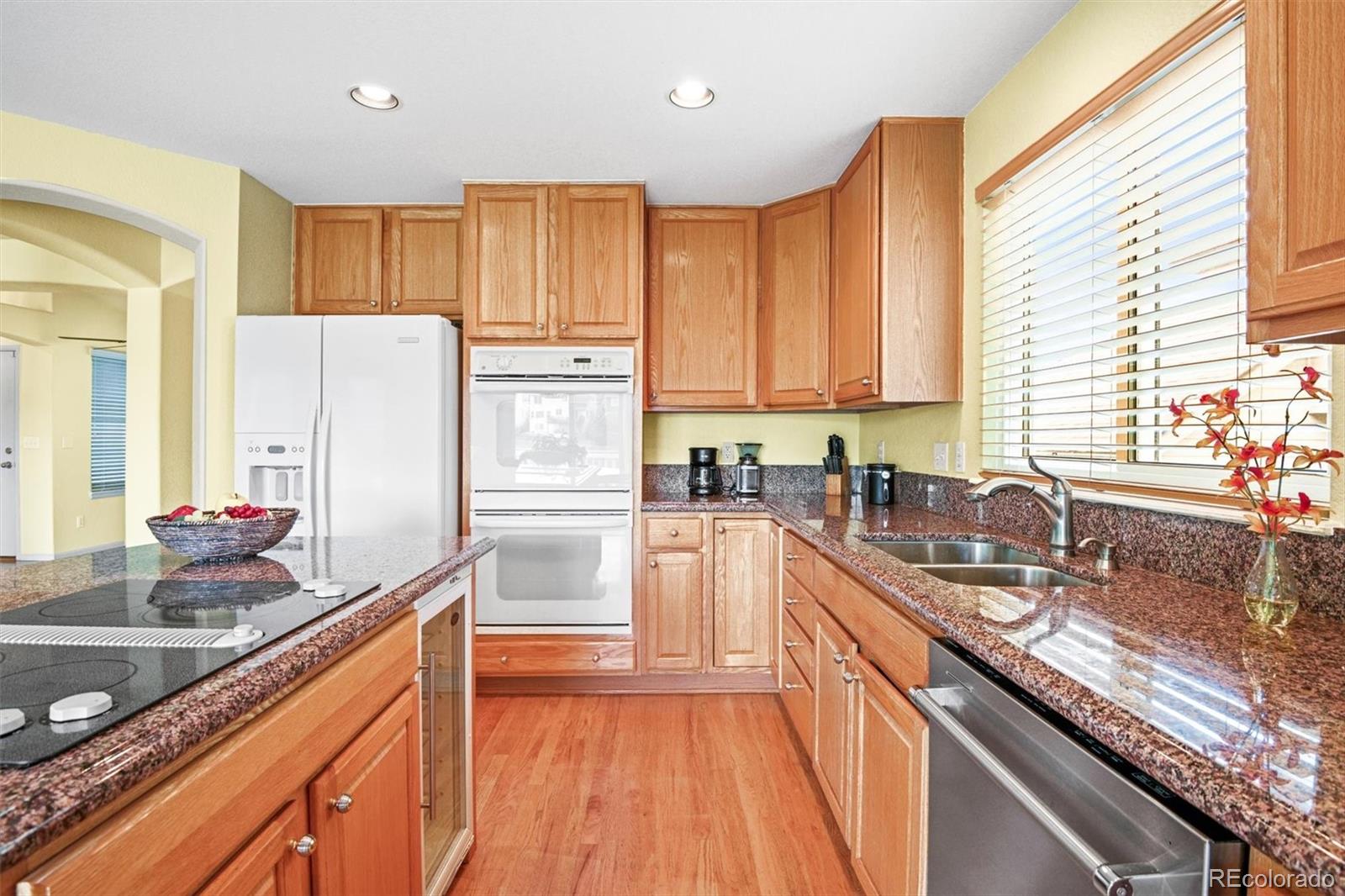 10230 Rustic Redwood Way Highlands Ranch, CO 80126 - Photo 14 of 50 a kitchen with granite countertop a sink stove refrigerator and cabinets