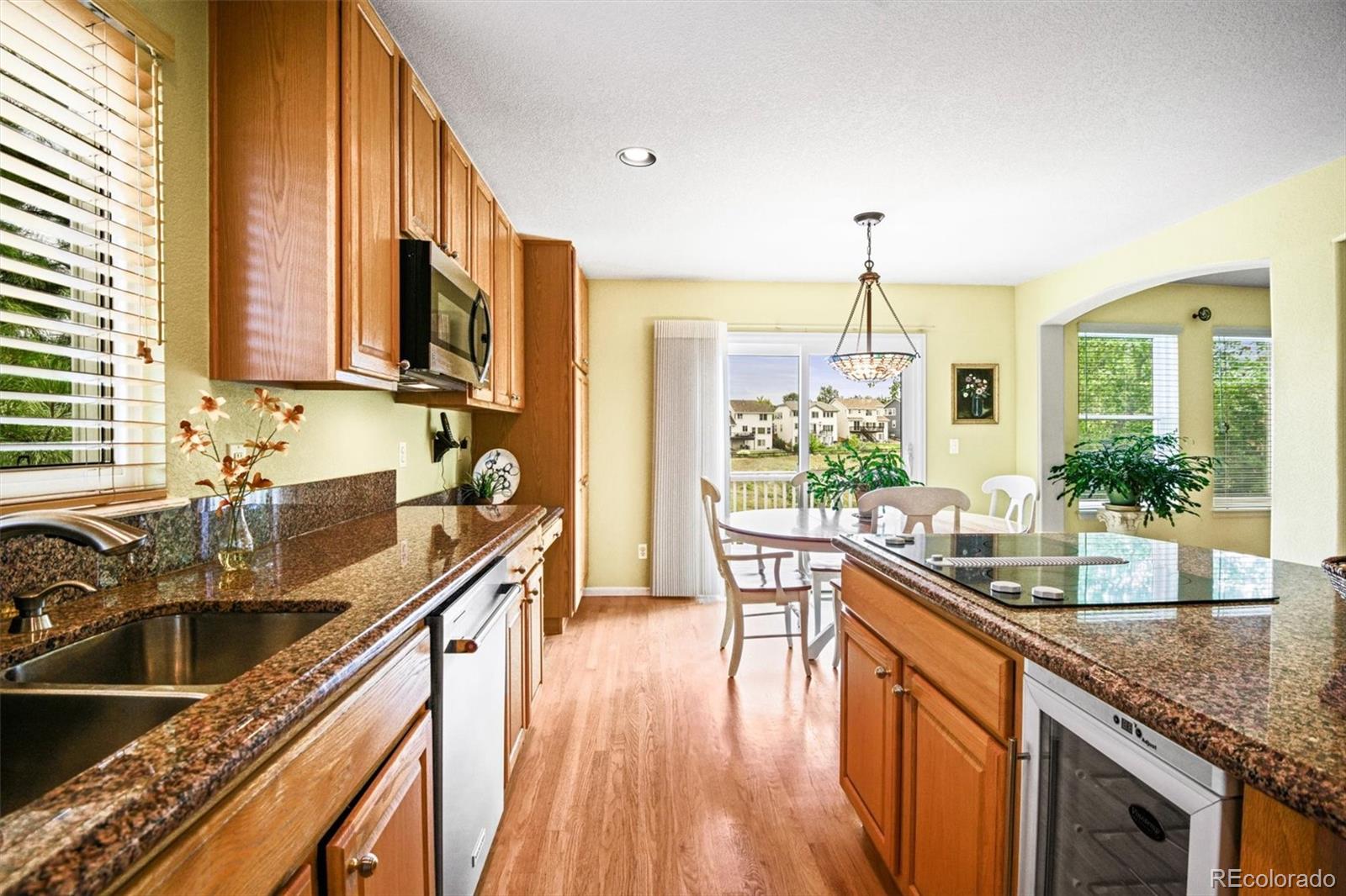 10230 Rustic Redwood Way Highlands Ranch, CO 80126 - Photo 15 of 50 a kitchen with stainless steel appliances granite countertop a sink stove and cabinets