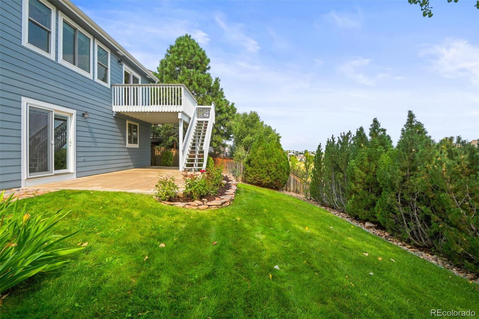 10230 Rustic Redwood Way Highlands Ranch, CO 80126 - Photo 42 of 50 a view of a house with a yard and potted plants