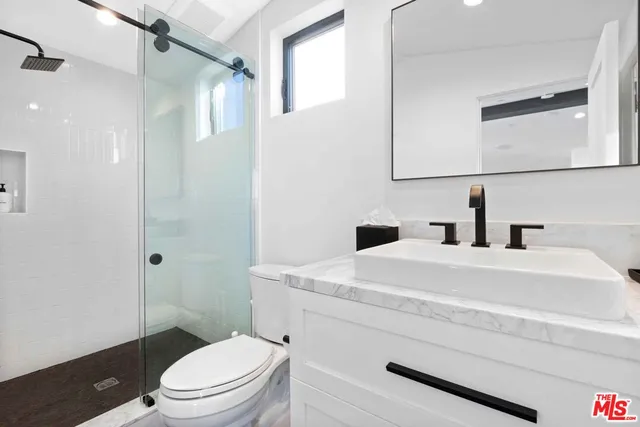 a bathroom with a sink a toilet and shower