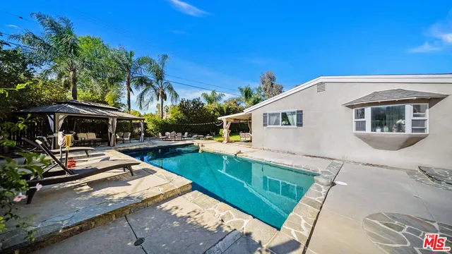 a view of a house with backyard and sitting area