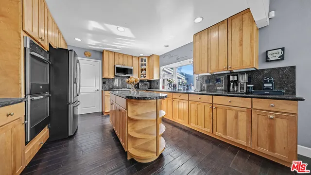 a kitchen with stainless steel appliances granite countertop a sink a stove and a refrigerator