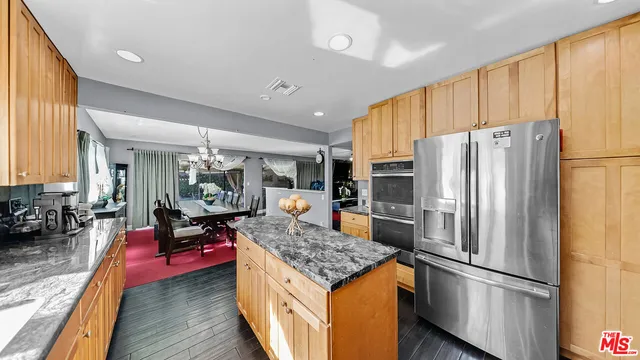 a kitchen with stainless steel appliances granite countertop a refrigerator stove and sink