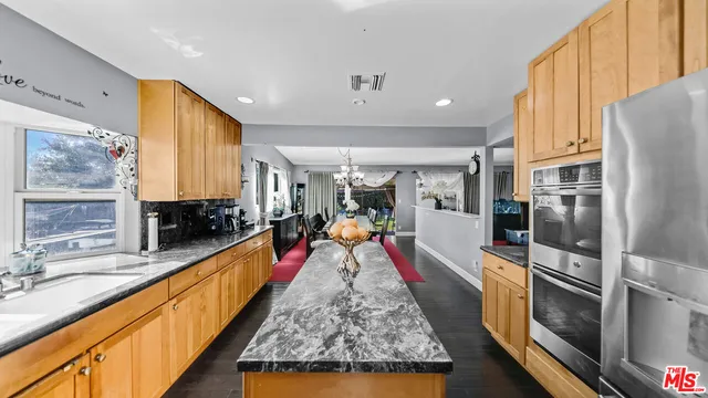 a large kitchen with lots of counter space and wooden floor