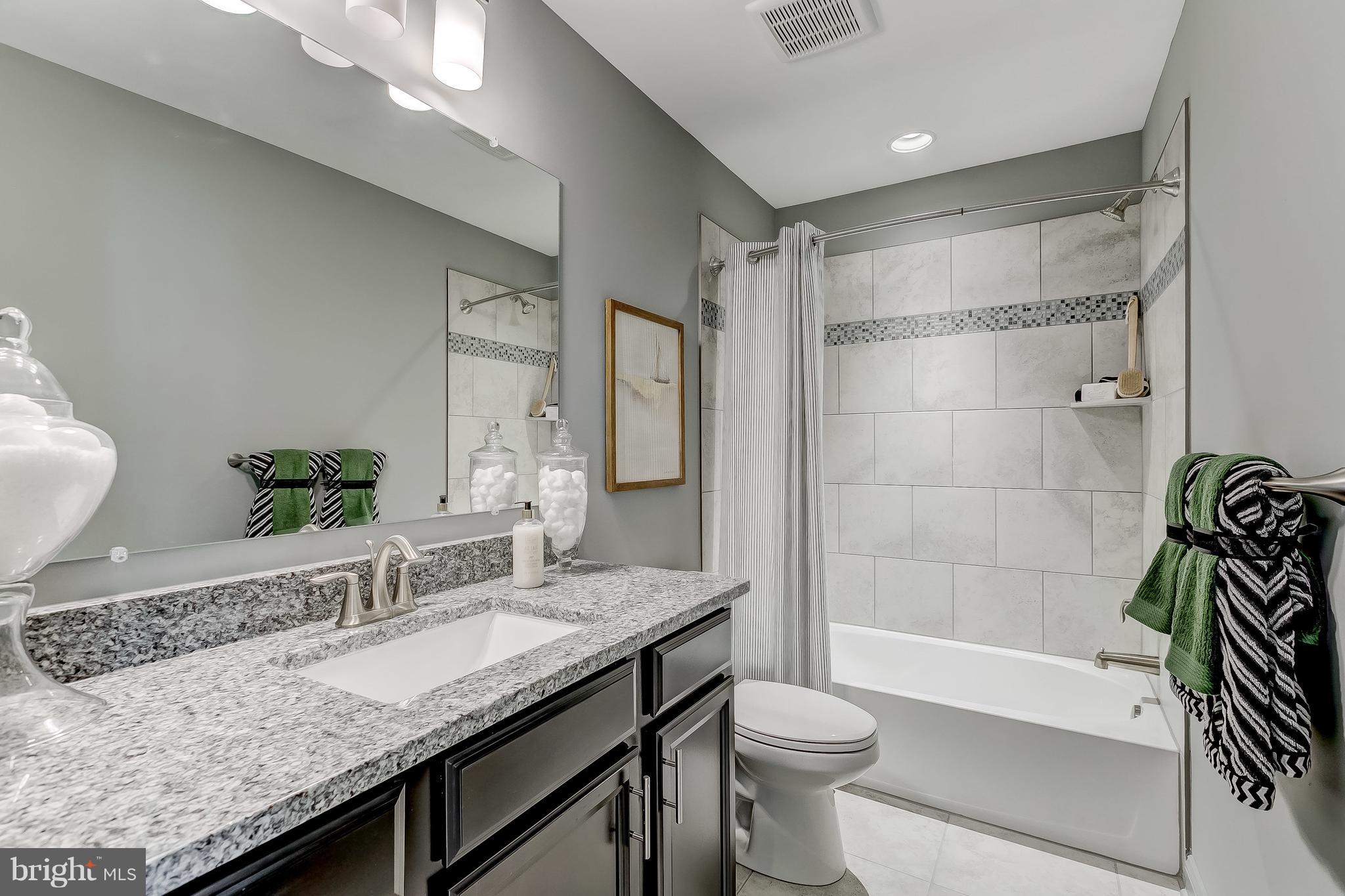 2714 Lady Slipper Road Gambrills, MD 21054 - Photo 27 of 46 a bathroom with a granite countertop sink a toilet a mirror and shower
