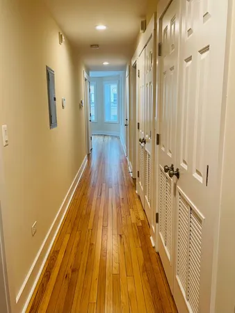 a view of a hallway with wooden floor and staircase