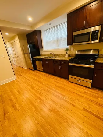 a kitchen with stainless steel appliances wooden cabinets and a stove top oven