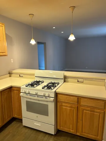 a kitchen with a stove and a wooden floors