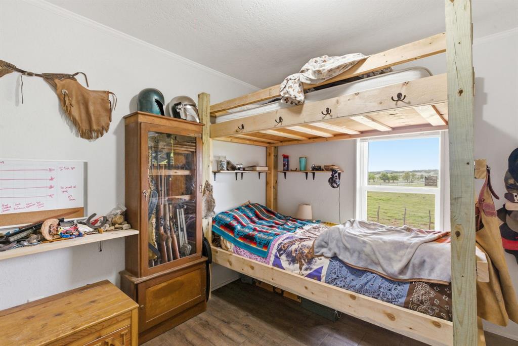 8315 County Road 403 Cisco, TX 76437 - Photo 14 of 40 a bedroom with a bed and wooden floor