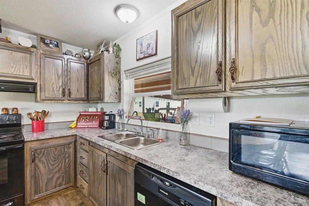 8315 County Road 403 Cisco, TX 76437 - Photo 10 of 40 a kitchen with stainless steel appliances granite countertop a sink stove and cabinets