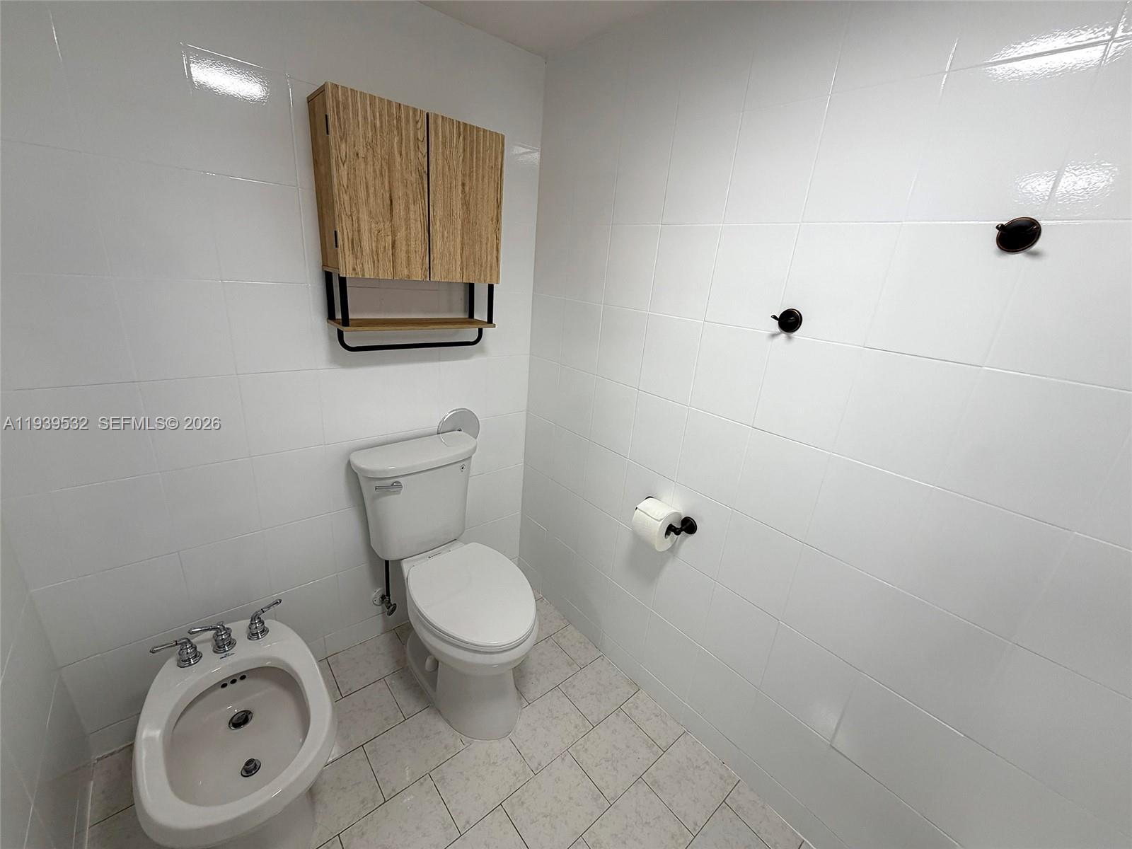 11755 Southwest 18th Street, Unit 109 Miami, FL 33175 - Photo 12 of 21 a bathroom with a toilet sink and mirror