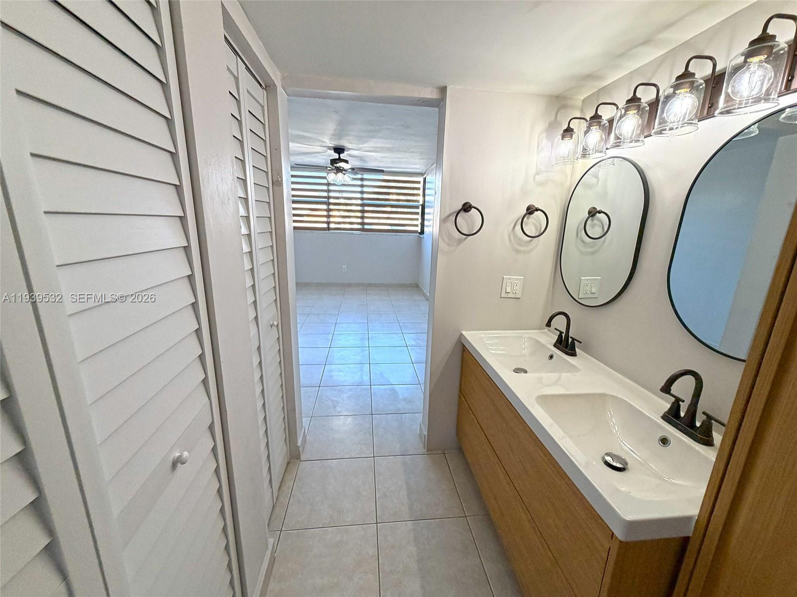 11755 Southwest 18th Street, Unit 109 Miami, FL 33175 - Photo 13 of 21 a bathroom with a sink a toilet and a mirror