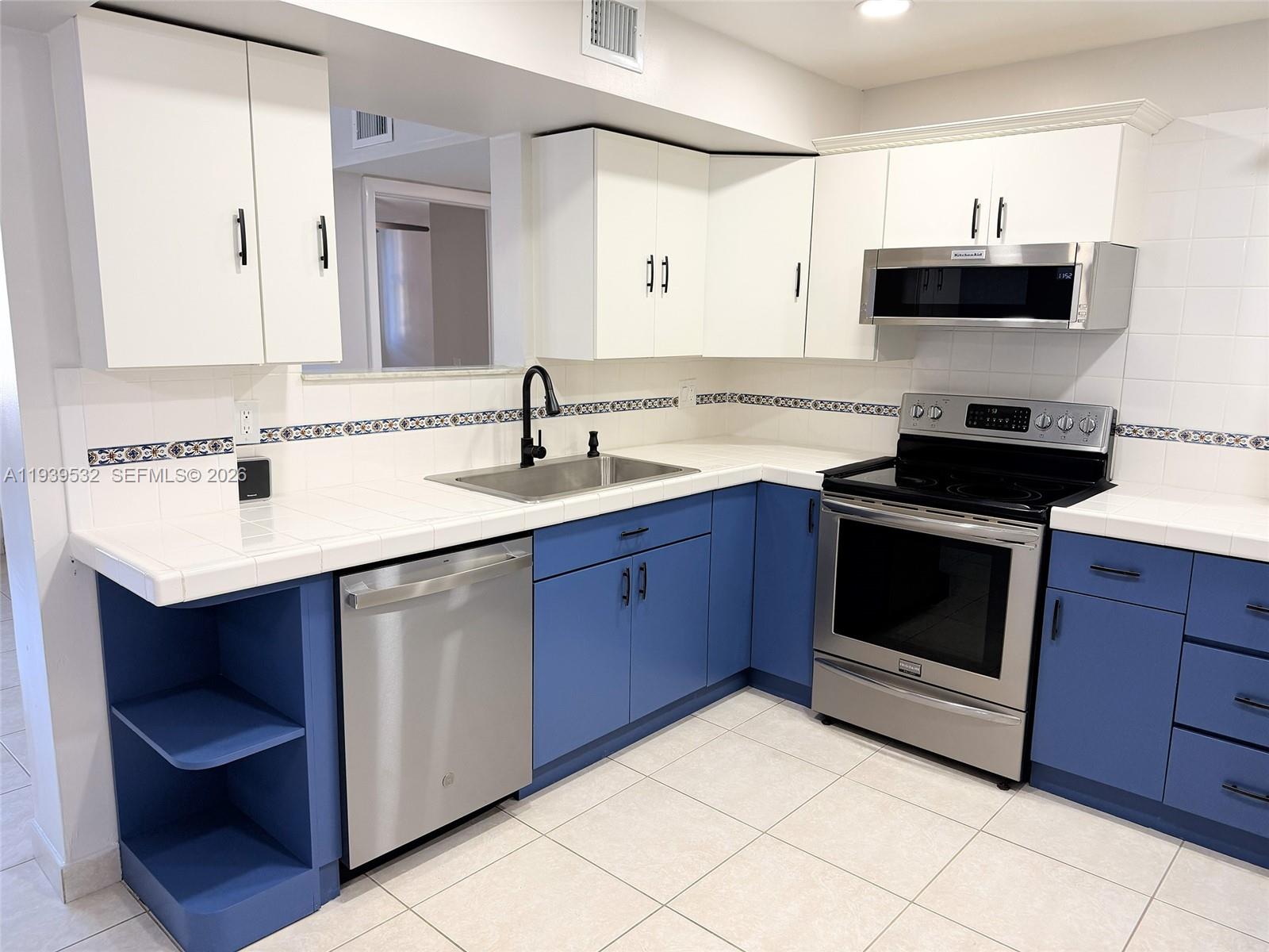 11755 Southwest 18th Street, Unit 109 Miami, FL 33175 - Photo 4 of 21 a kitchen with a sink and a stove top oven