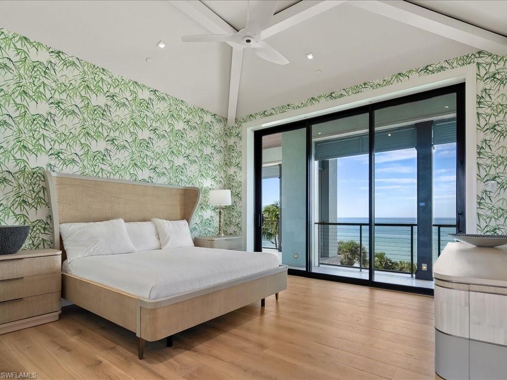 7409 Bay Colony Drive Naples, FL 34108 - Photo 16 of 46 Bedroom with wallpapered walls, a water view, access to exterior, light wood-style floors, and ceiling fan