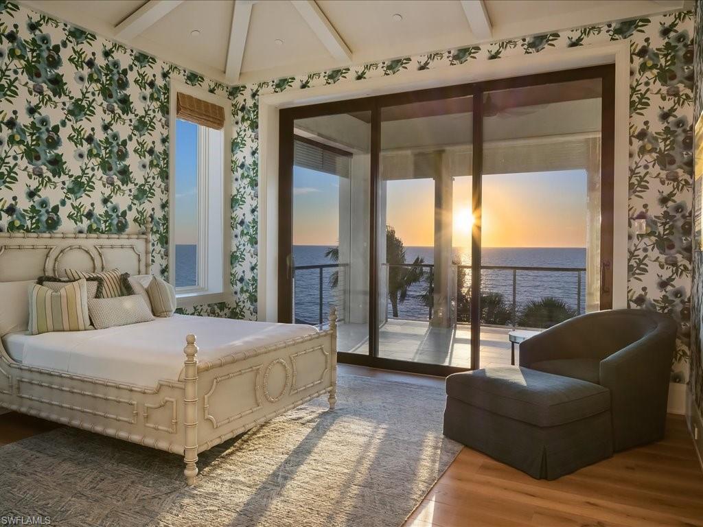 7409 Bay Colony Drive Naples, FL 34108 - Photo 20 of 48 a bedroom with a large bed and a chandelier