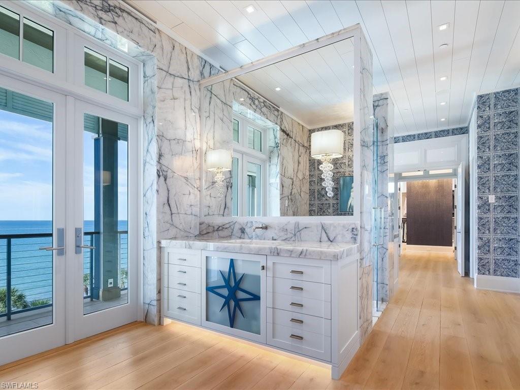7409 Bay Colony Drive Naples, FL 34108 - Photo 25 of 46 Bathroom featuring vanity, french doors, light wood-type flooring, recessed lighting, and a water view