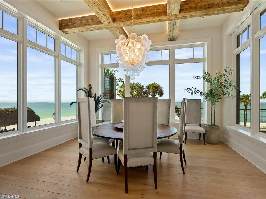 7409 Bay Colony Drive Naples, FL 34108 - Photo 32 of 48 a view of a dining room with furniture a chandelier and wooden floor