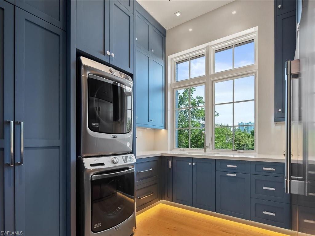 7409 Bay Colony Drive Naples, FL 34108 - Photo 35 of 48 a kitchen with a sink a washer and dryer