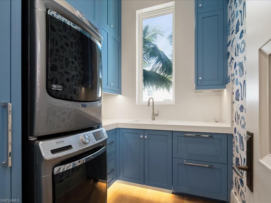 7409 Bay Colony Drive Naples, FL 34108 - Photo 36 of 46 Laundry area featuring stacked washing machine and dryer and cabinet space