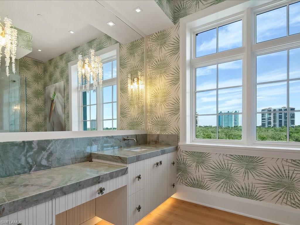 7409 Bay Colony Drive Naples, FL 34108 - Photo 39 of 48 a bathroom with a granite countertop sink and a large mirror