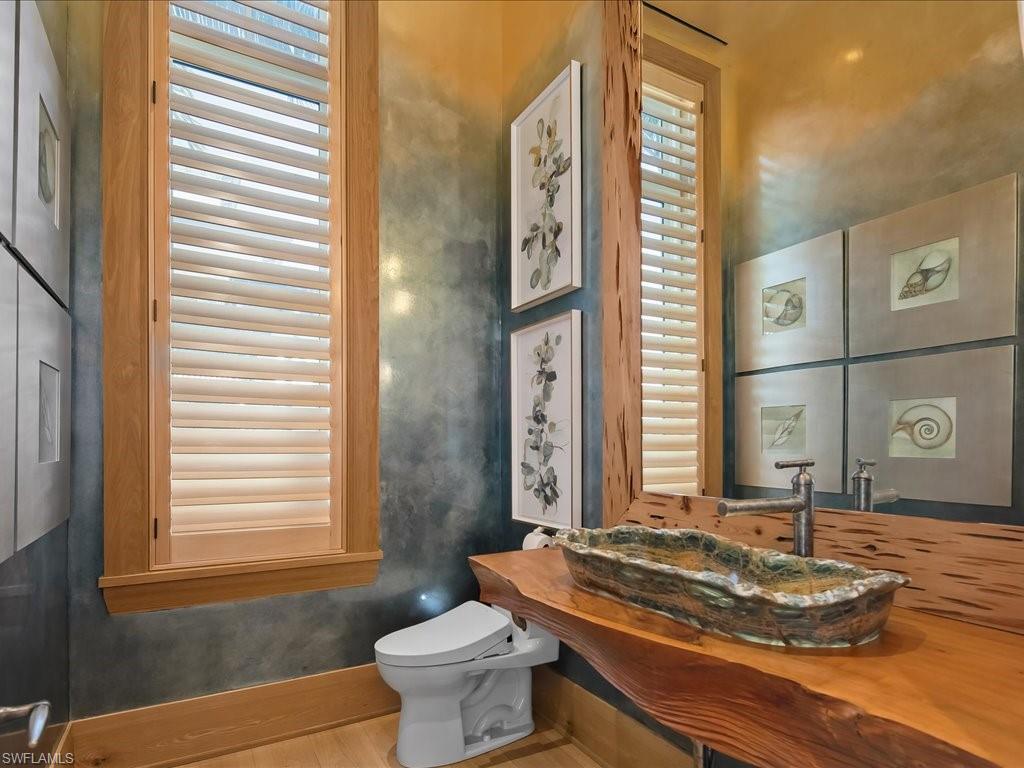 7409 Bay Colony Drive Naples, FL 34108 - Photo 43 of 48 a bathroom with a granite countertop sink and a mirror