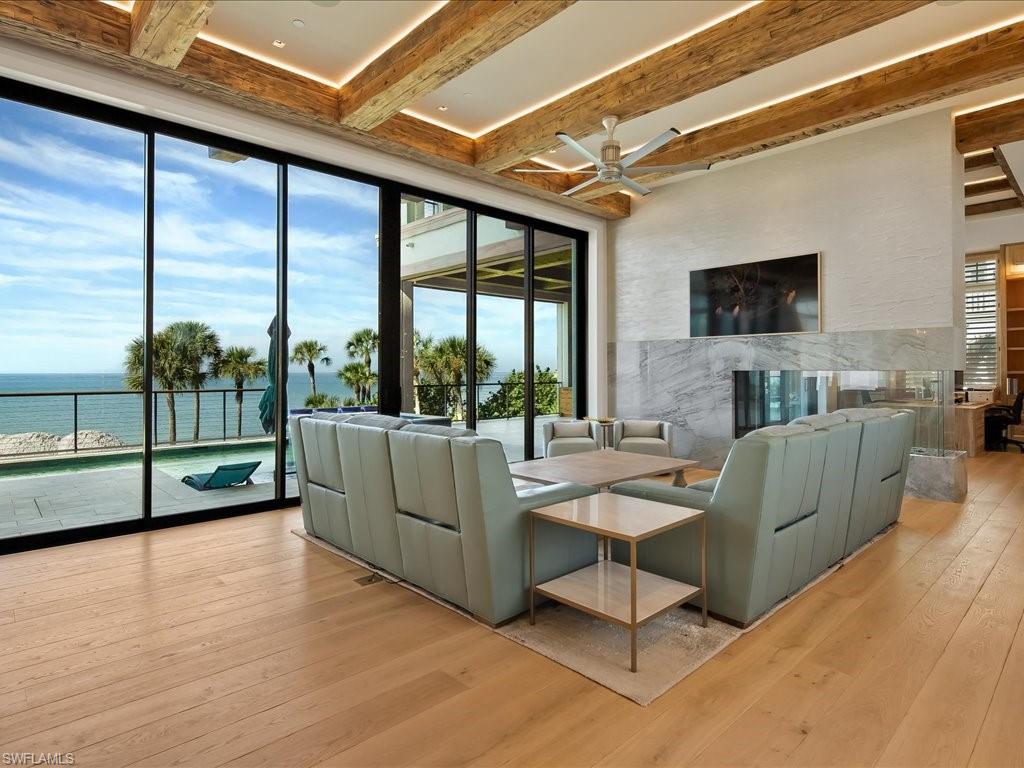 7409 Bay Colony Drive Naples, FL 34108 - Photo 8 of 46 Living room with a water view, beam ceiling, light wood-type flooring, and ceiling fan