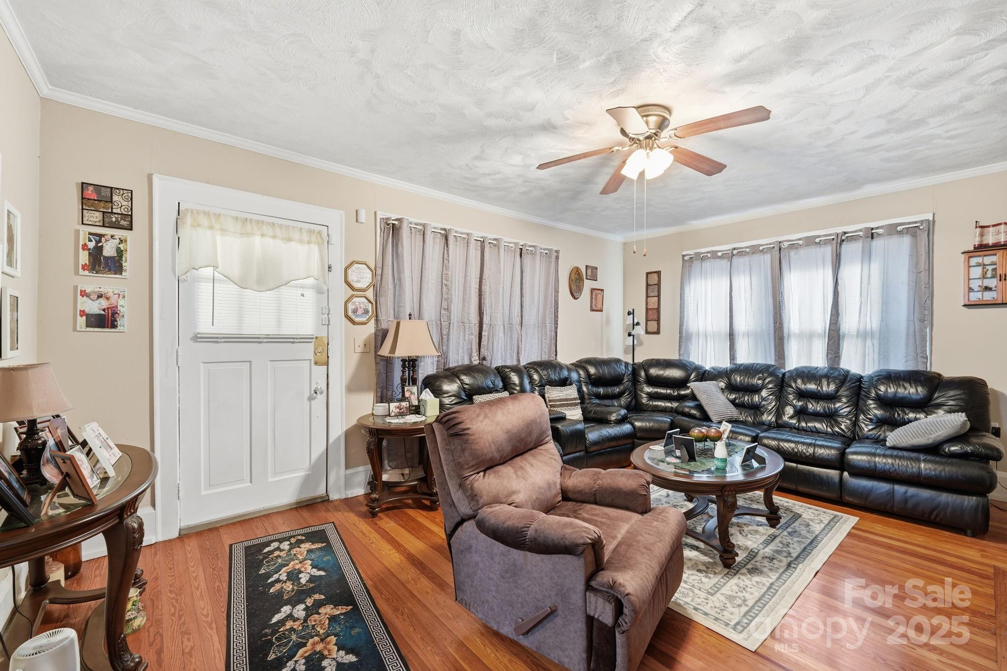 105 1st Street Rockingham, NC 28379 - Photo 4 of 28 a living room with furniture a ceiling fan and a rug