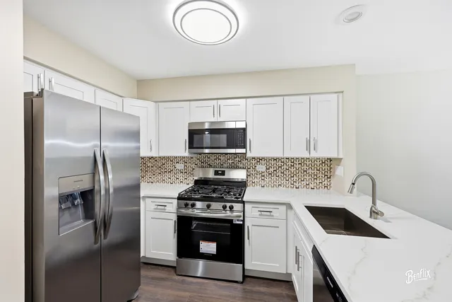 a kitchen with stainless steel appliances granite countertop a refrigerator stove and sink