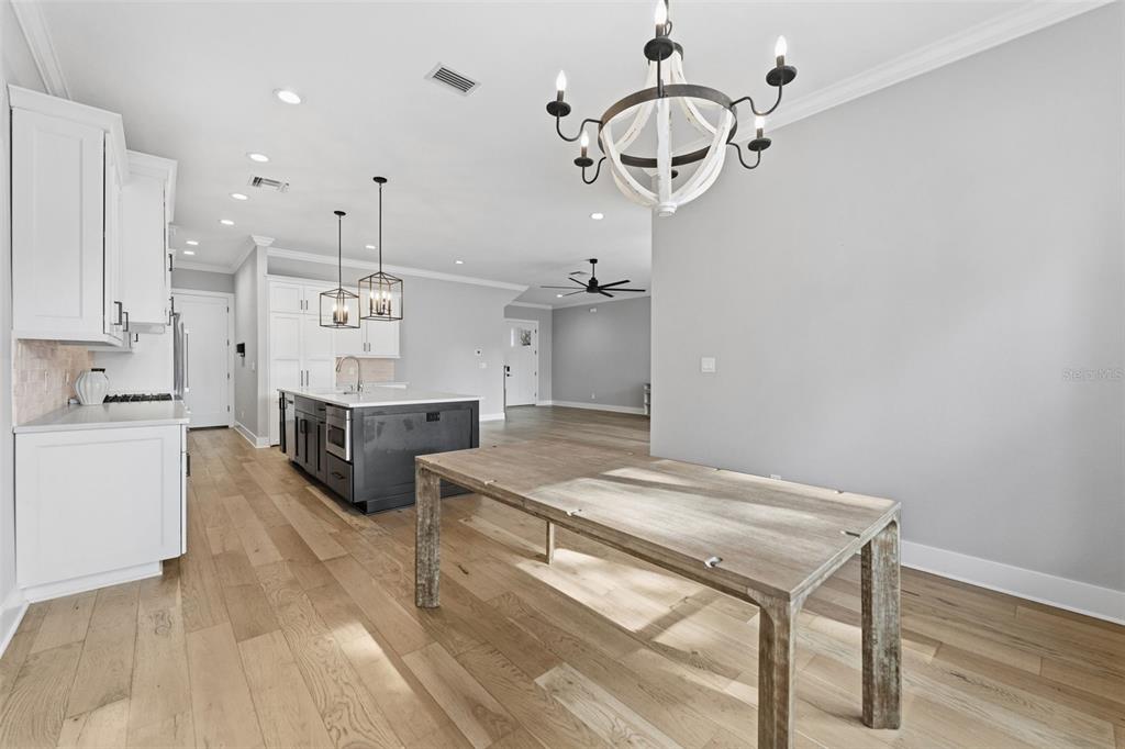 3314 West Villa Rosa Street Tampa, FL 33611 - Photo 12 of 55 a open kitchen with kitchen island a stove a sink dishwasher and white cabinets with wooden floor