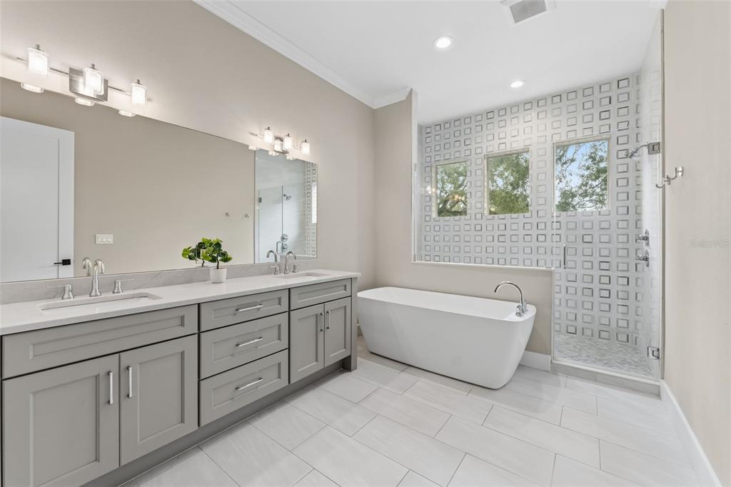 3314 West Villa Rosa Street Tampa, FL 33611 - Photo 18 of 55 a bathroom with a double vanity sink a large mirror a bathtub and