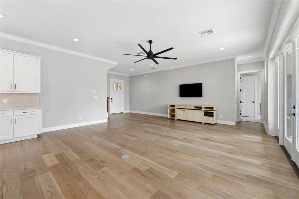 3314 West Villa Rosa Street Tampa, FL 33611 - Photo 7 of 55 a view of a livingroom with a flat screen tv wooden floor and a ceiling fan