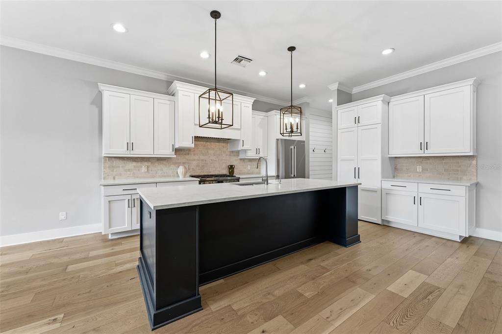 3314 West Villa Rosa Street Tampa, FL 33611 - Photo 8 of 55 a large kitchen with stainless steel appliances kitchen island granite countertop a stove a sink and white cabinets