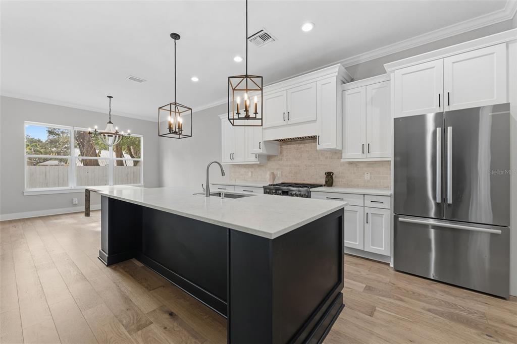 3314 West Villa Rosa Street Tampa, FL 33611 - Photo 9 of 55 a kitchen with stainless steel appliances granite countertop a sink a stove a refrigerator and island with wooden floor