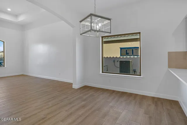 a view of a room with wooden floor chandelier and a window