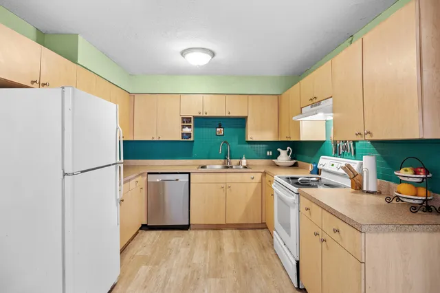 a kitchen with a sink a refrigerator and cabinets