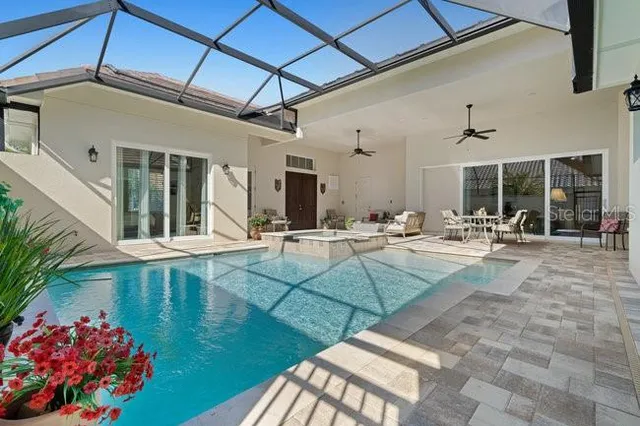 a living room with furniture large windows and flat screen tv