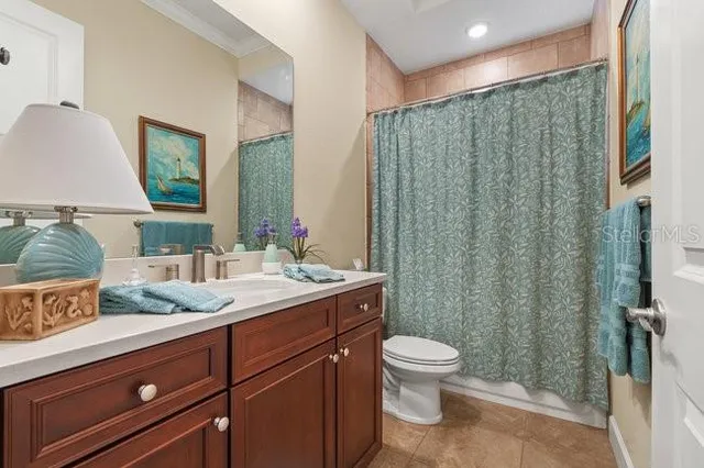 a bedroom with a bed a chandelier and a flat screen television