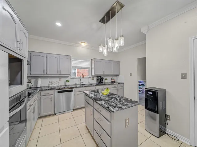 a kitchen with a stove a sink a refrigerator and cabinets