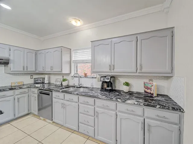 a kitchen with stainless steel appliances granite countertop white cabinets sink and dishwasher