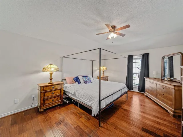 a bedroom with a bed and dresser with mirror